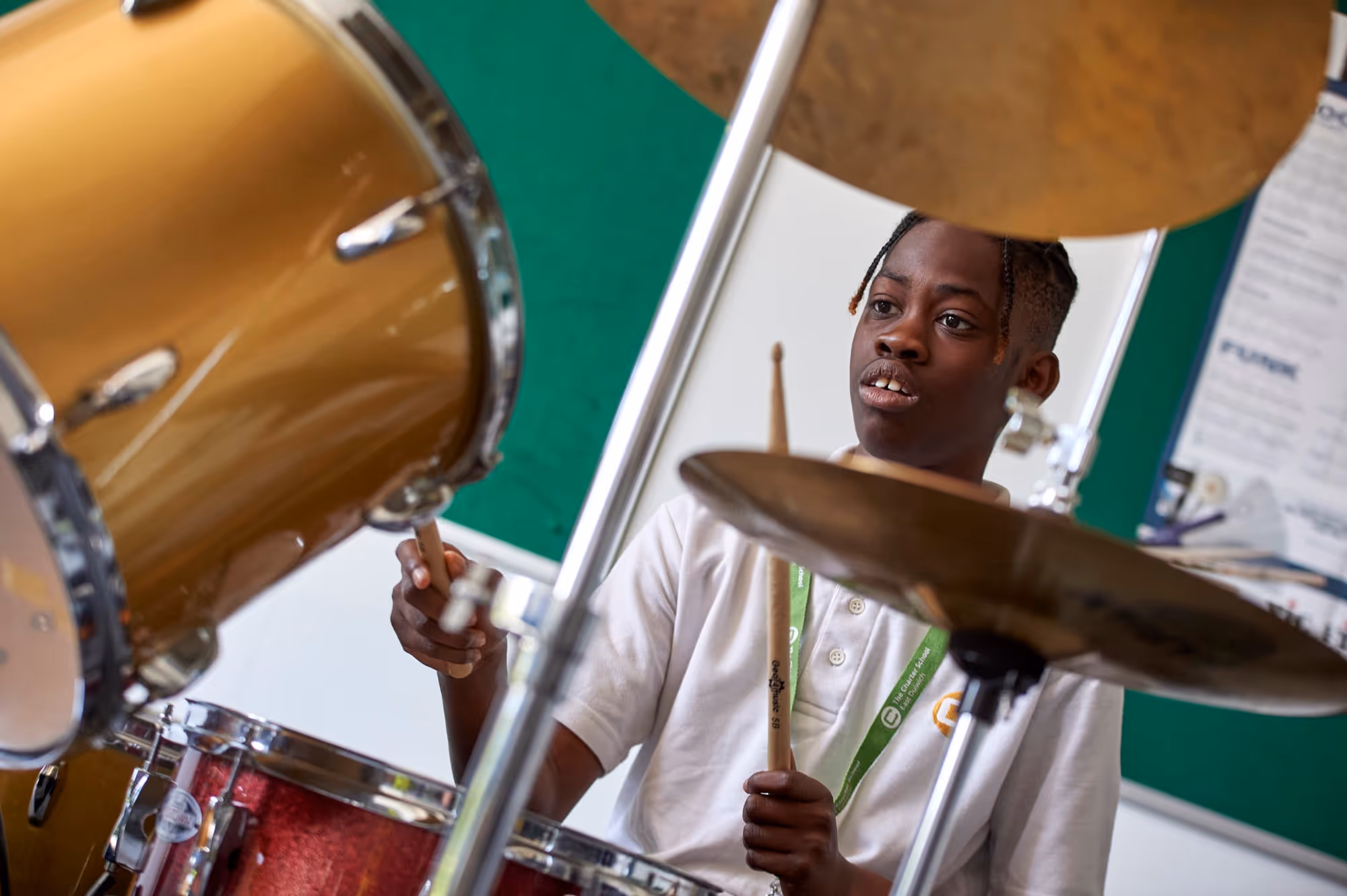 A student playing drums during a music lesson at The Charter School East Dulwich