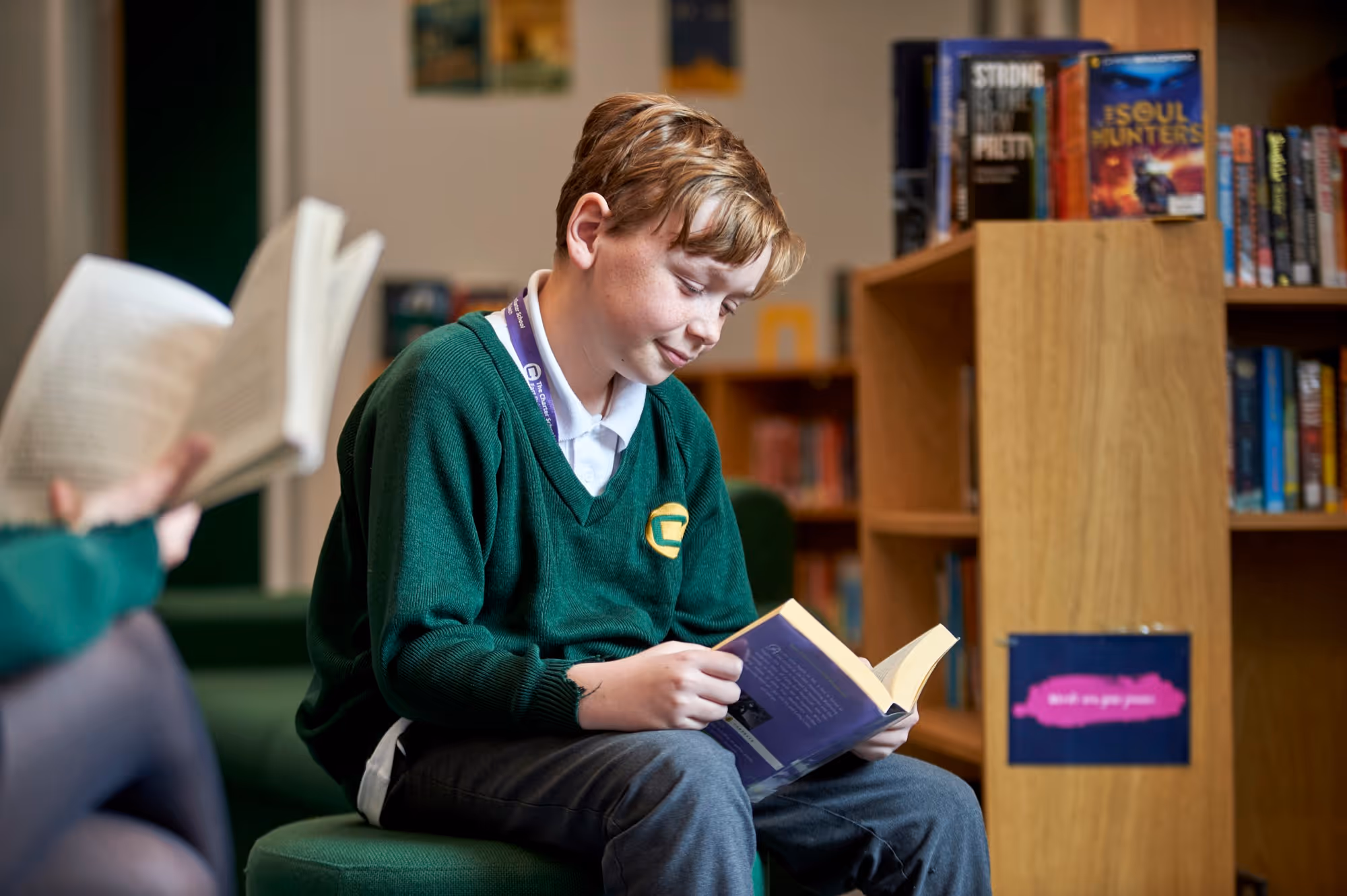 A student reading a book in the library at The Charter School East Dulwich