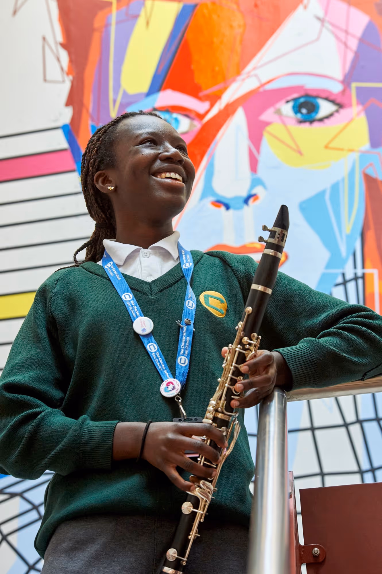 A student holds a clarinet at the top of the stairs at The Charter School East Dulwich