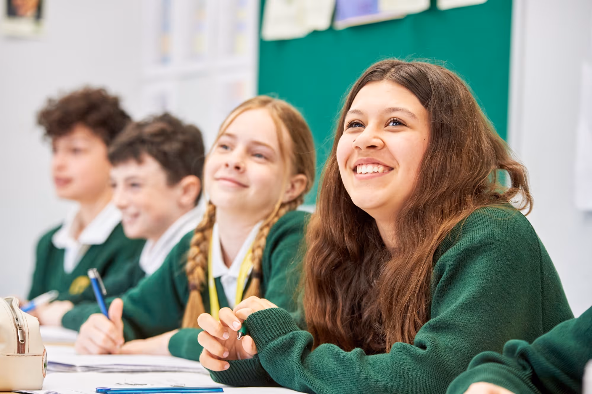 A group of students sat at desks looking forward during a lesson