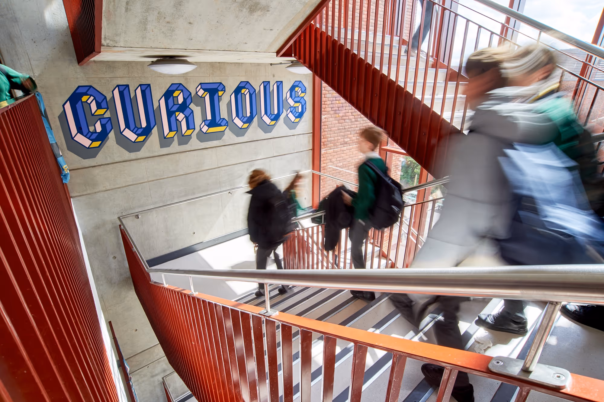interior stairs in the main building at The Charter School East Dulwich showing the word curious on the wall