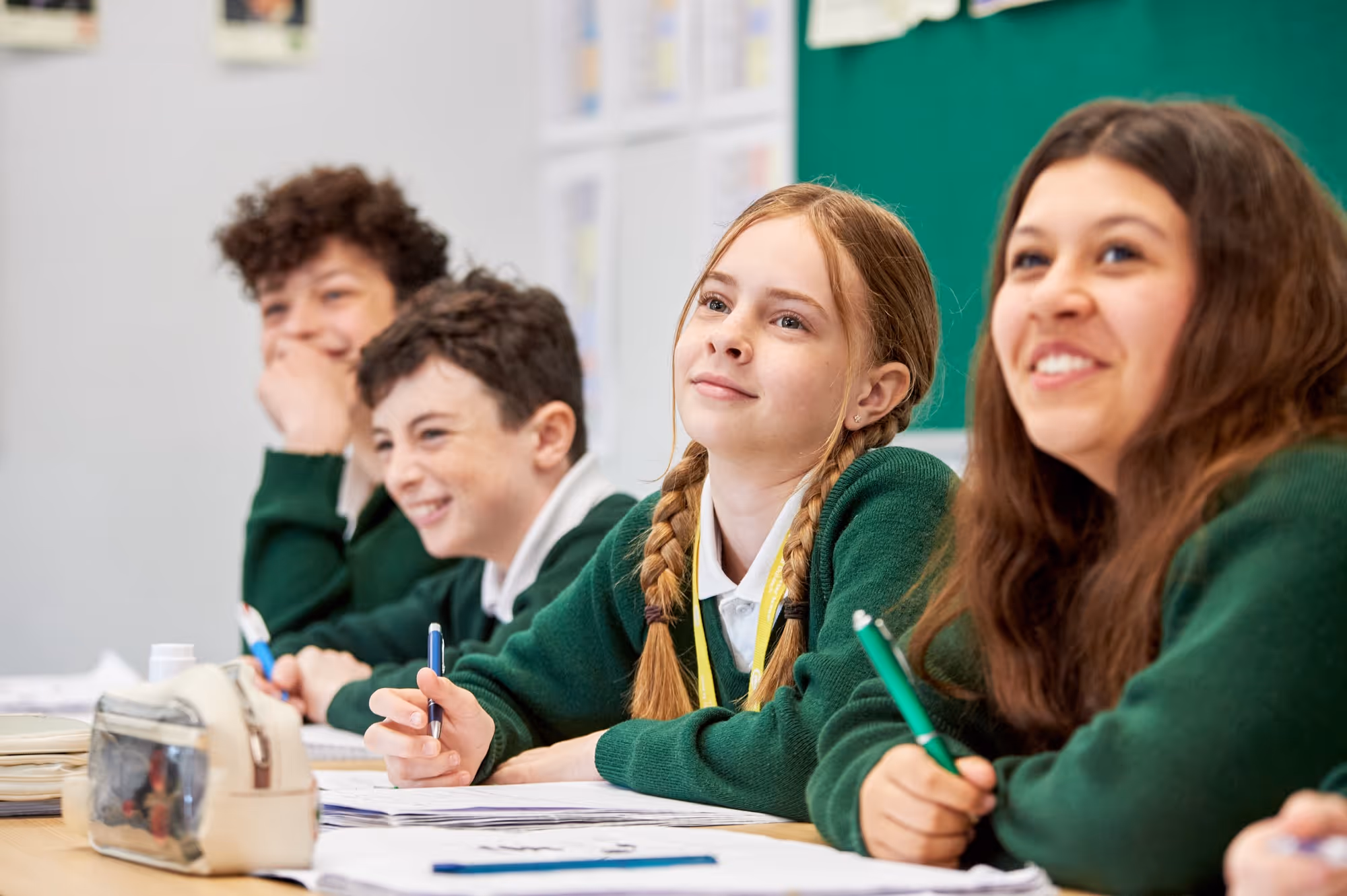 A group of students sat at desks looking forward during a lesson