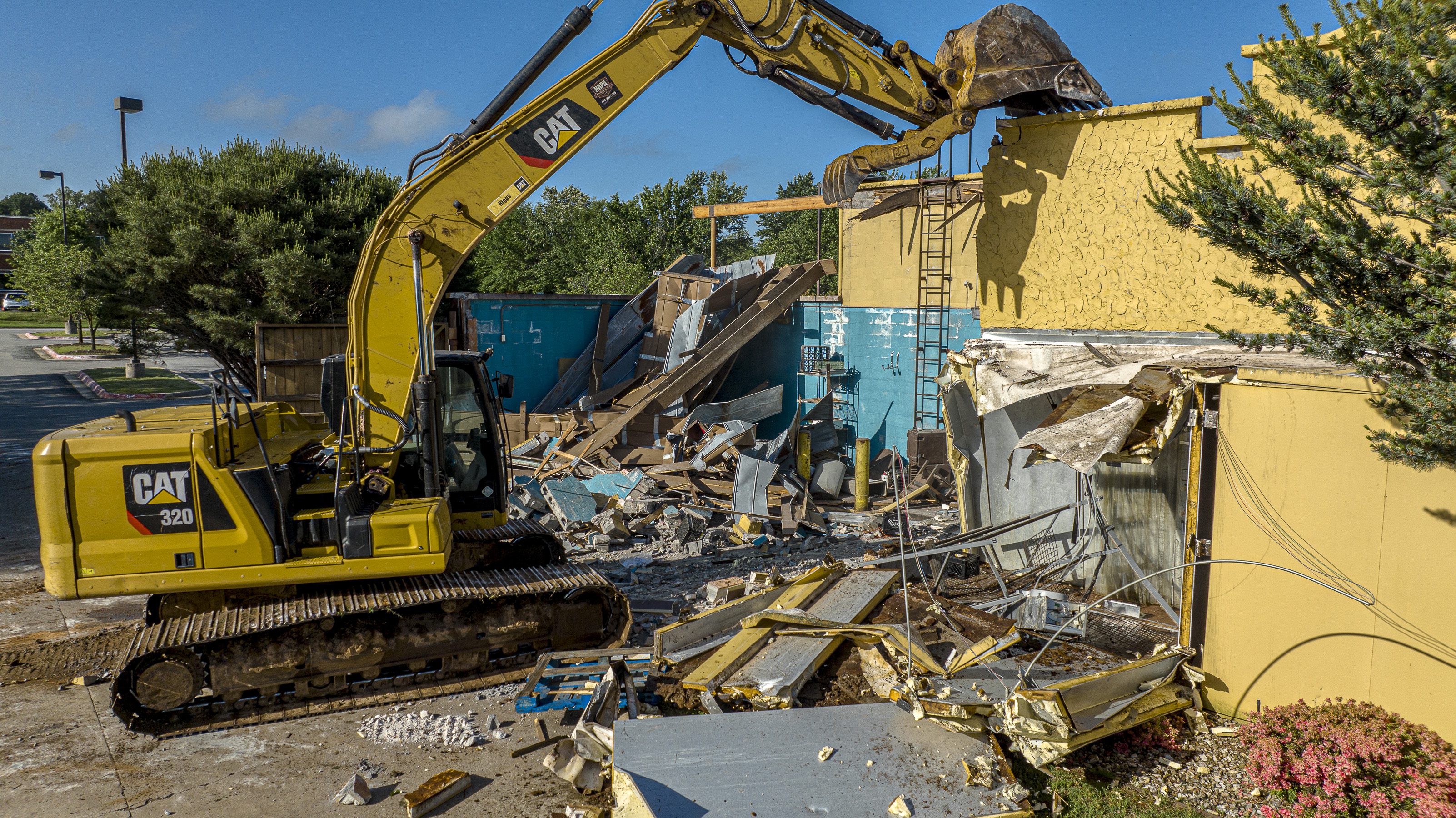 Excavator demolishing a commercial building