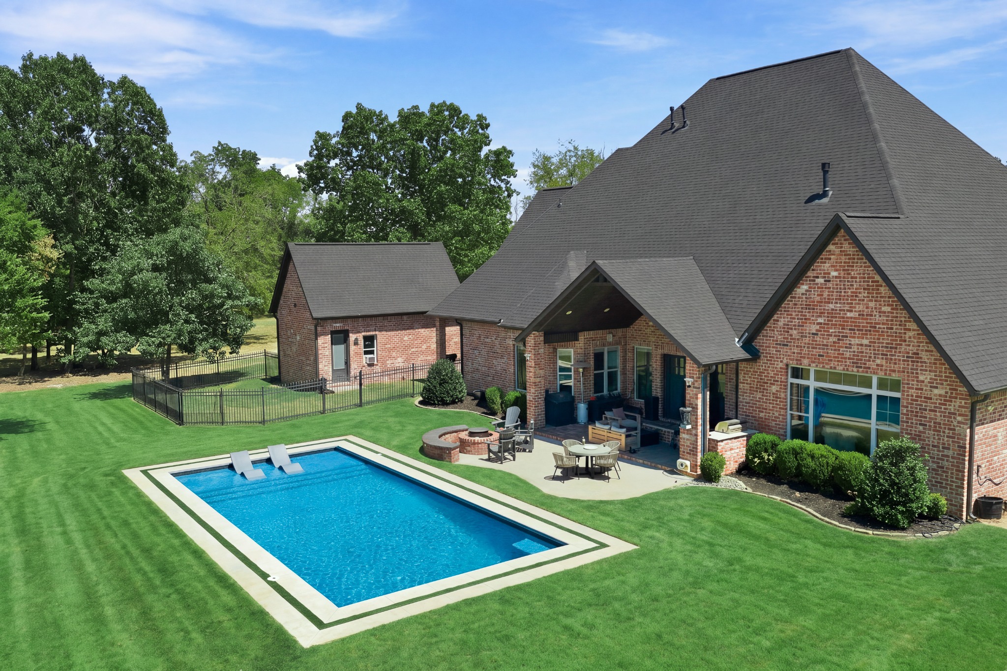 Green lawn beside a swimming pool and covered patio