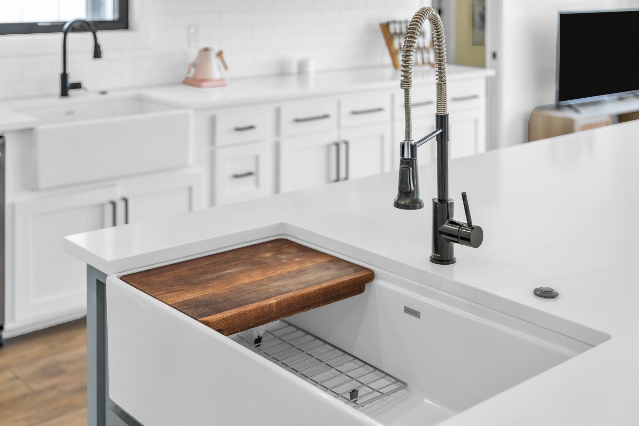 Kitchen detail with a farmhouse sink and spring-coil faucet