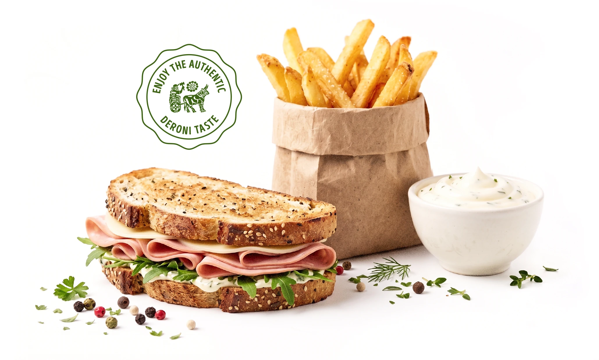 Salted French fries in a paper bag with a bowl of creamy herb dip and scattered herbs and peppercorns.