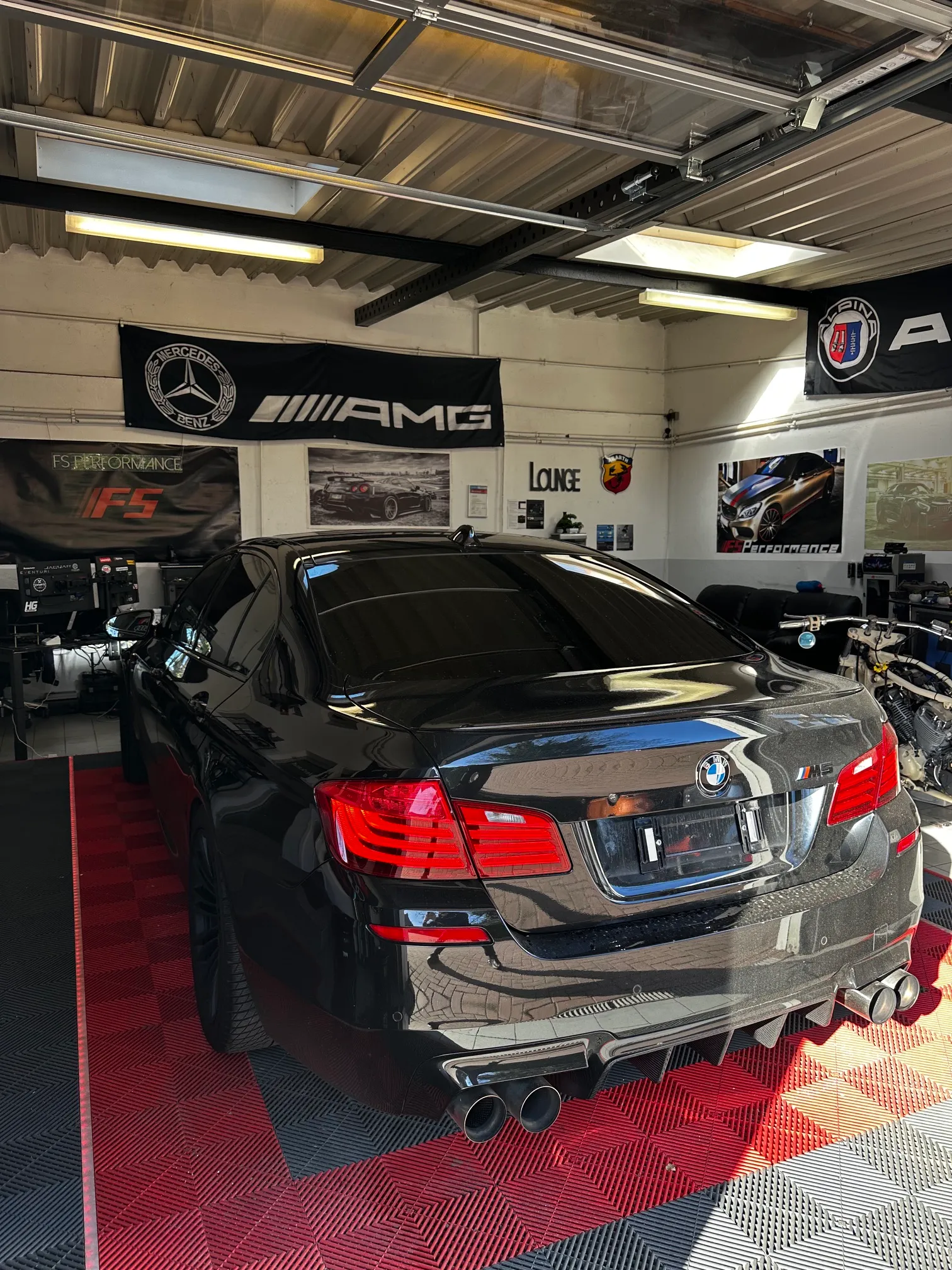 Heckansicht eines schwarzen BMW M-Modells mit FS Performance Kennzeichen in der Lounge in Hamburg