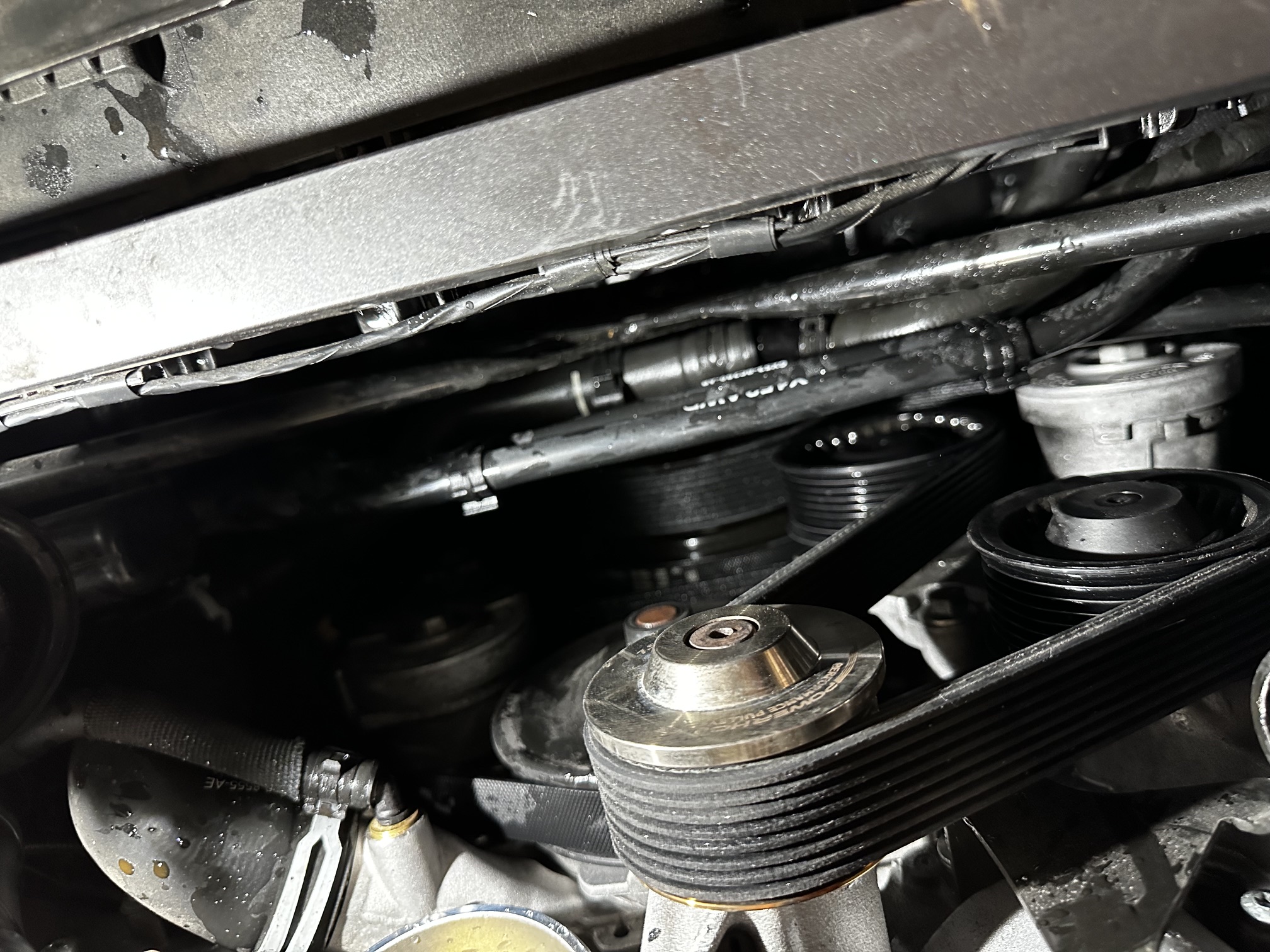 Detailaufnahme im Motorraum des Jaguar F-Type SVR mit Kompressor während des Pulley-Tausches bei FS Performance in Hamburg