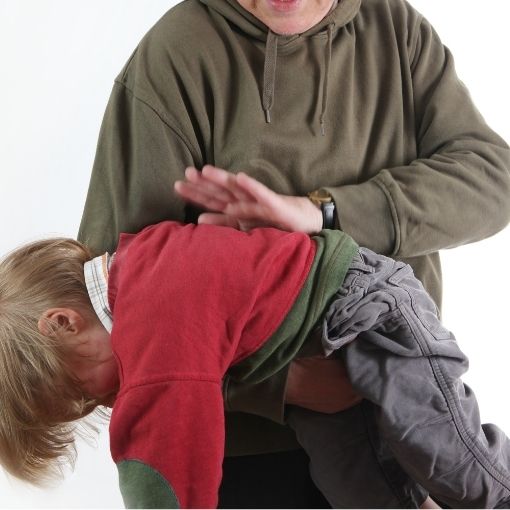 Adult wearing a green hoodie holding a child bent over, about to give a spanking.