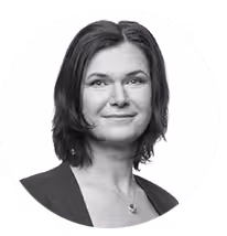 Black and white portrait of a woman with short hair wearing a blazer and a necklace.