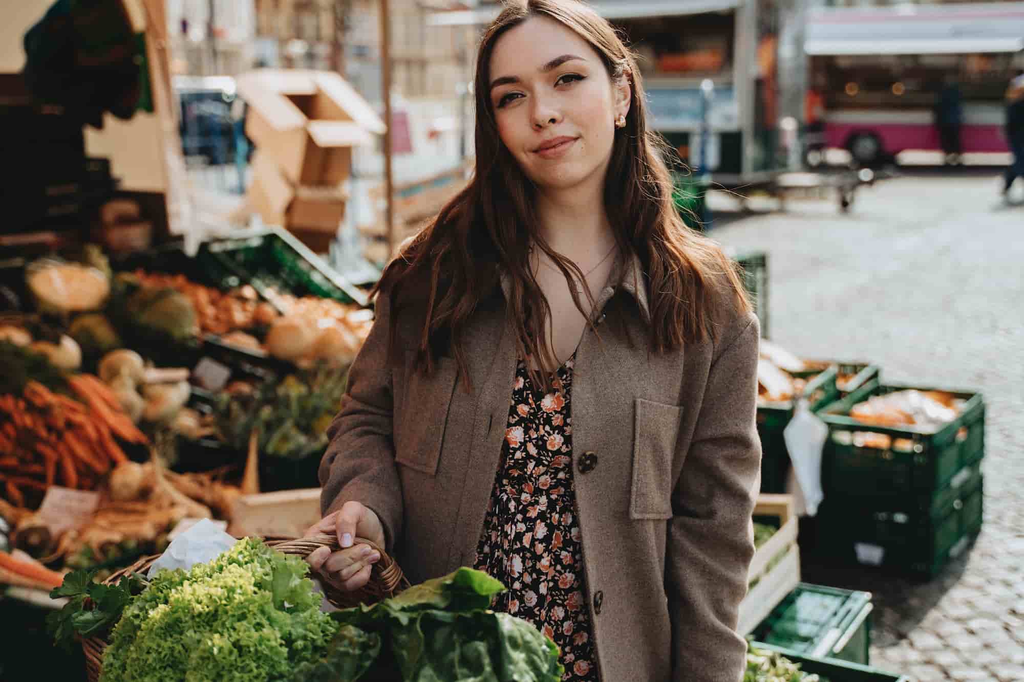 An image of a woman carrying a basket of fresh food