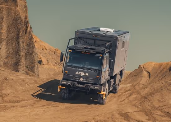 Grey Acela Monterra 4x4 with KRUG Expedition habitat box driving through desert terrain on an overland adventure
