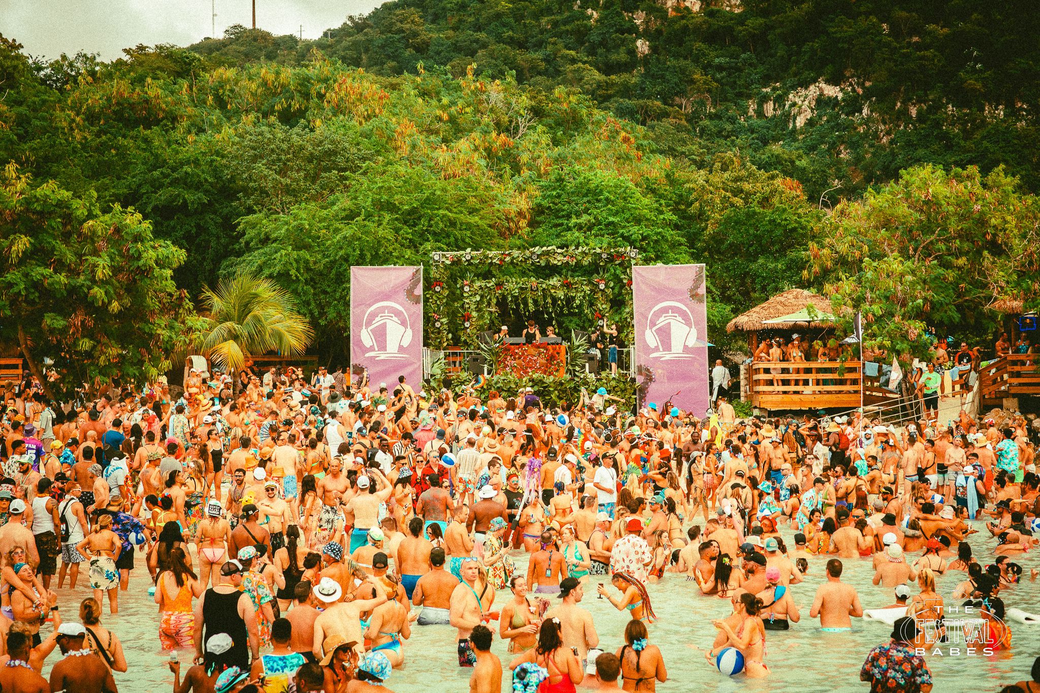 Crowd dancing in the water at EDM festival beach party