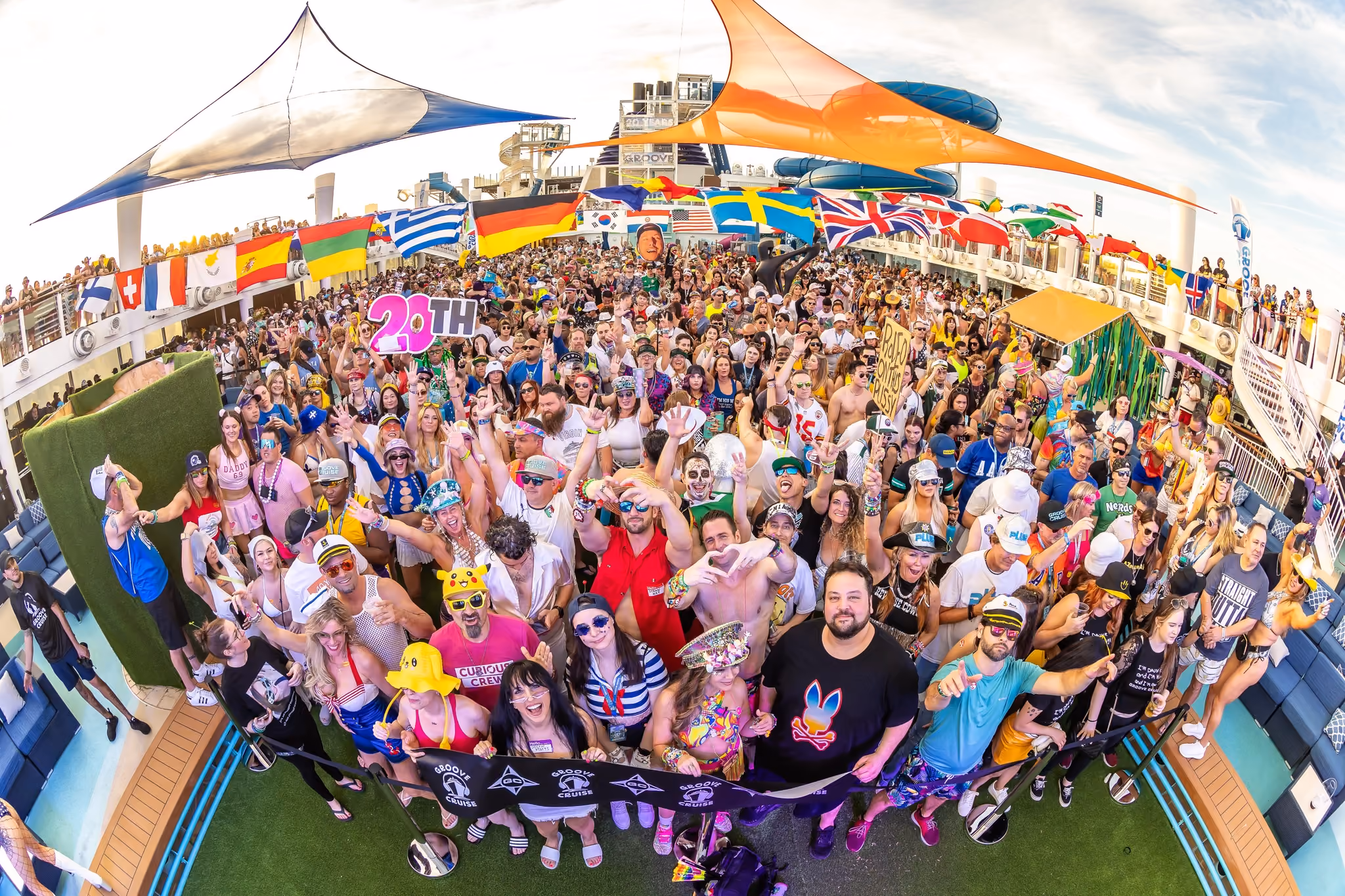 Groove Cruise crowd posing for group photo on pool deck stage