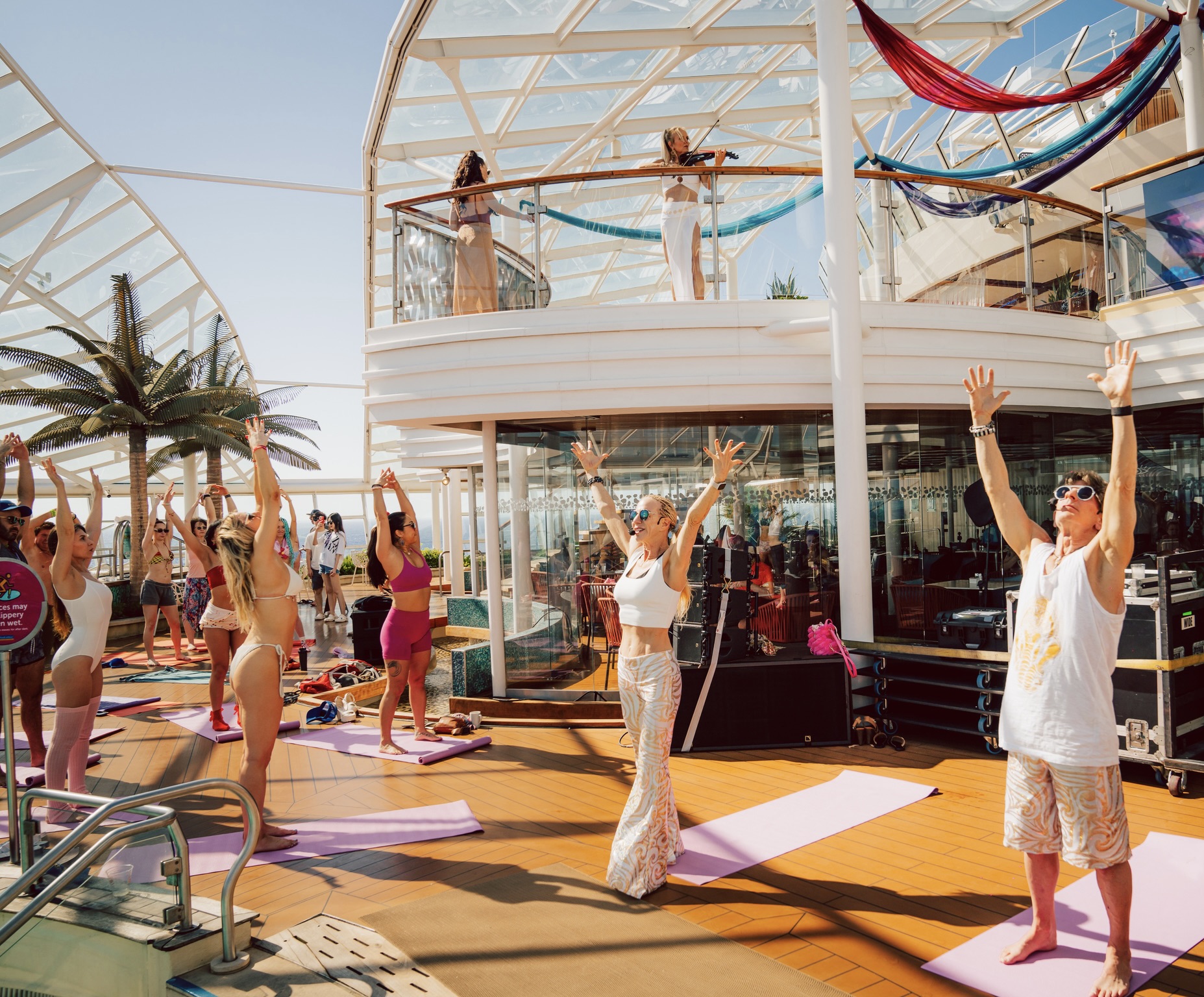 Festival cruise attendees take yoga class on ship deck