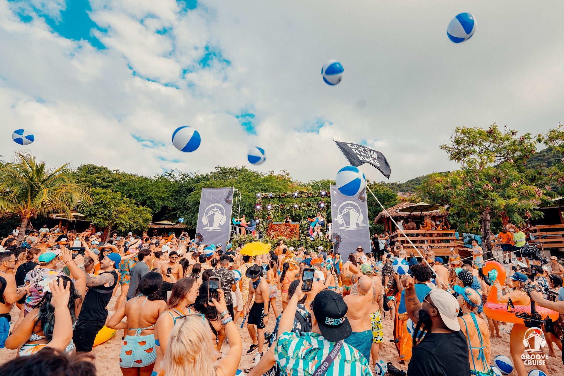 EDM cruise private beach party with palm trees and ocean views