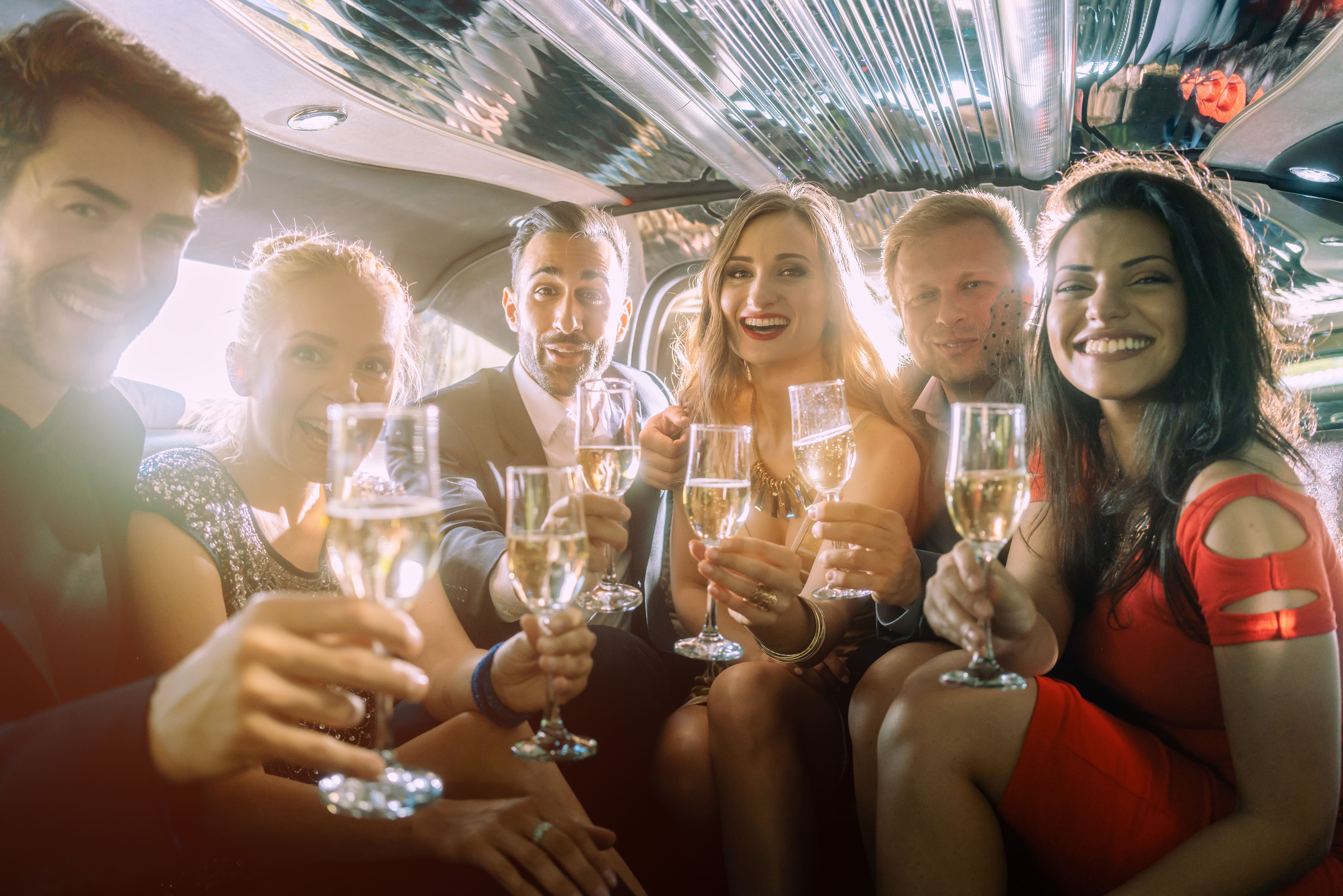 Bachelor party group toasting champagne on a party bus in Miami