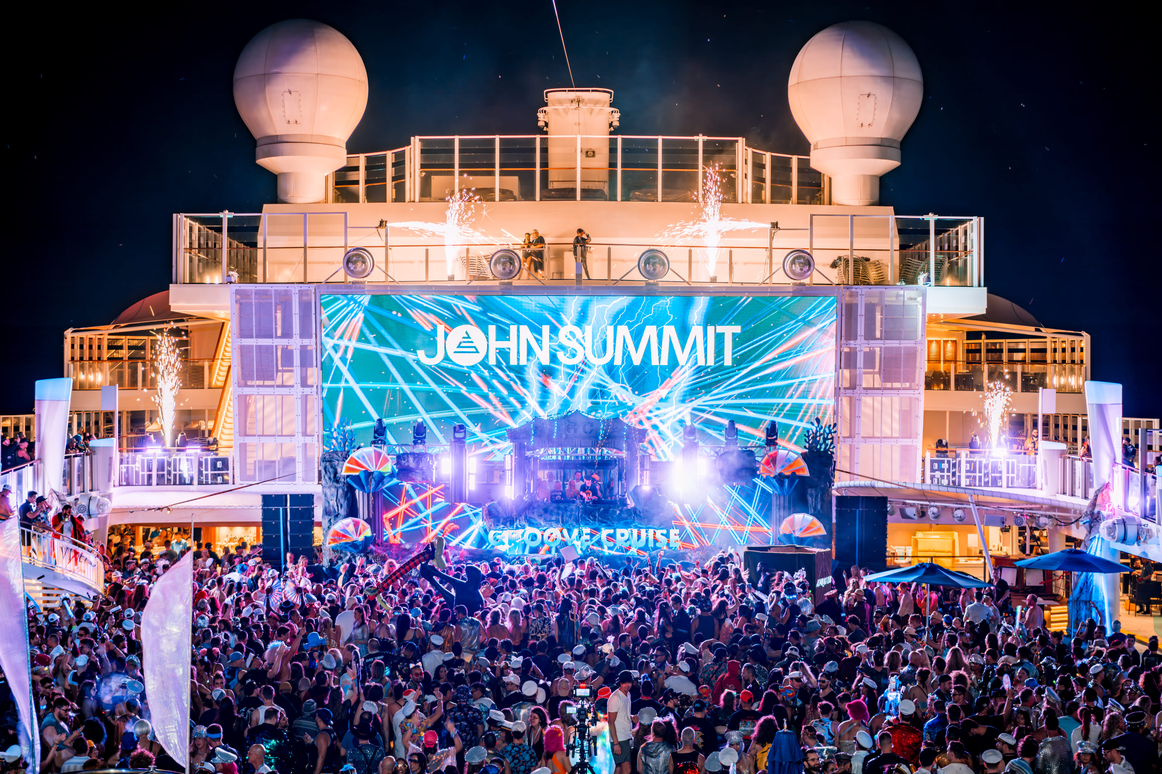 John Summit playing on the Groove Cruise main pool deck stage at night