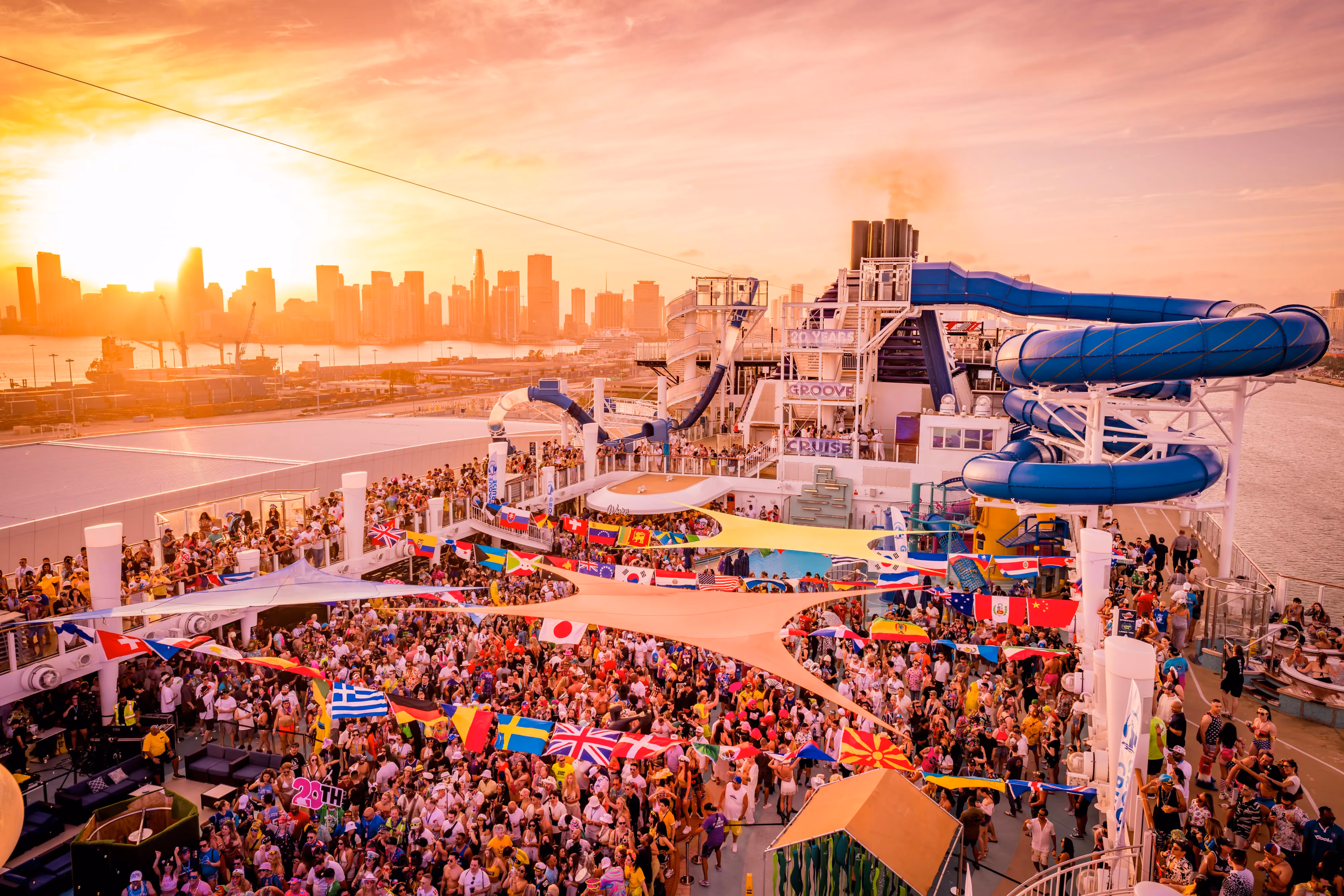 EDM festival attendees dancing at sunset on Groove Cruise top deck