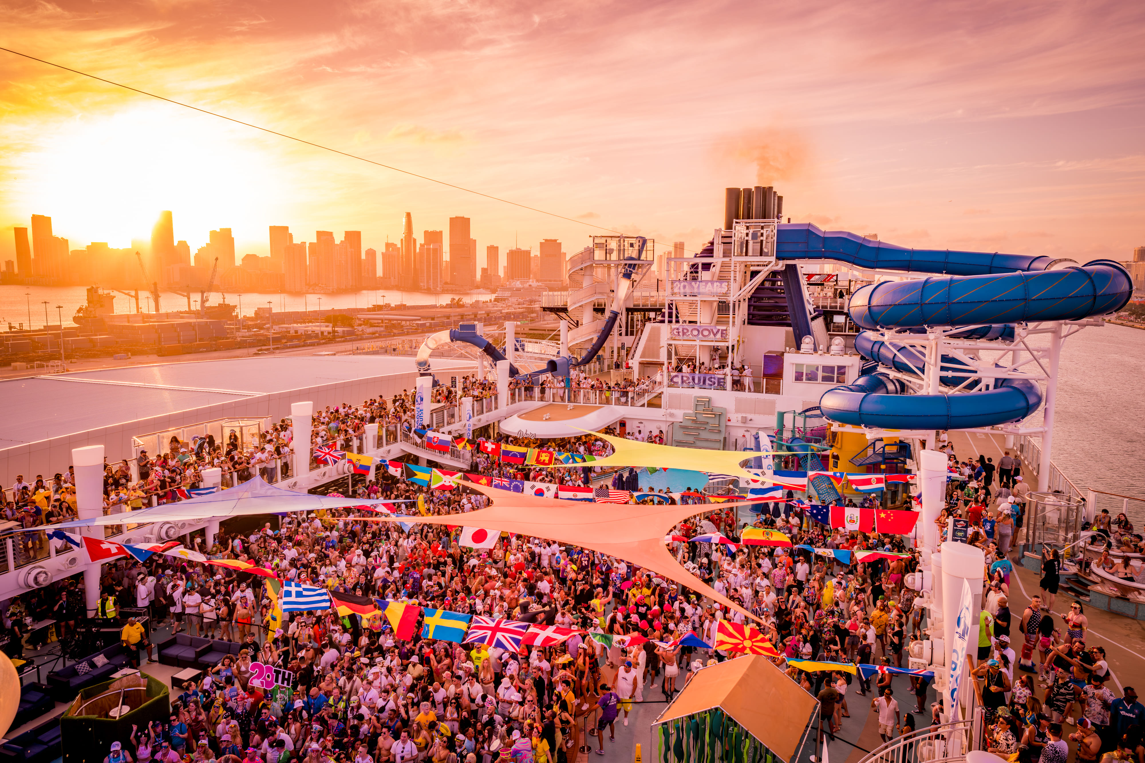 EDM festival attendees dancing at sunset on Groove Cruise top deck