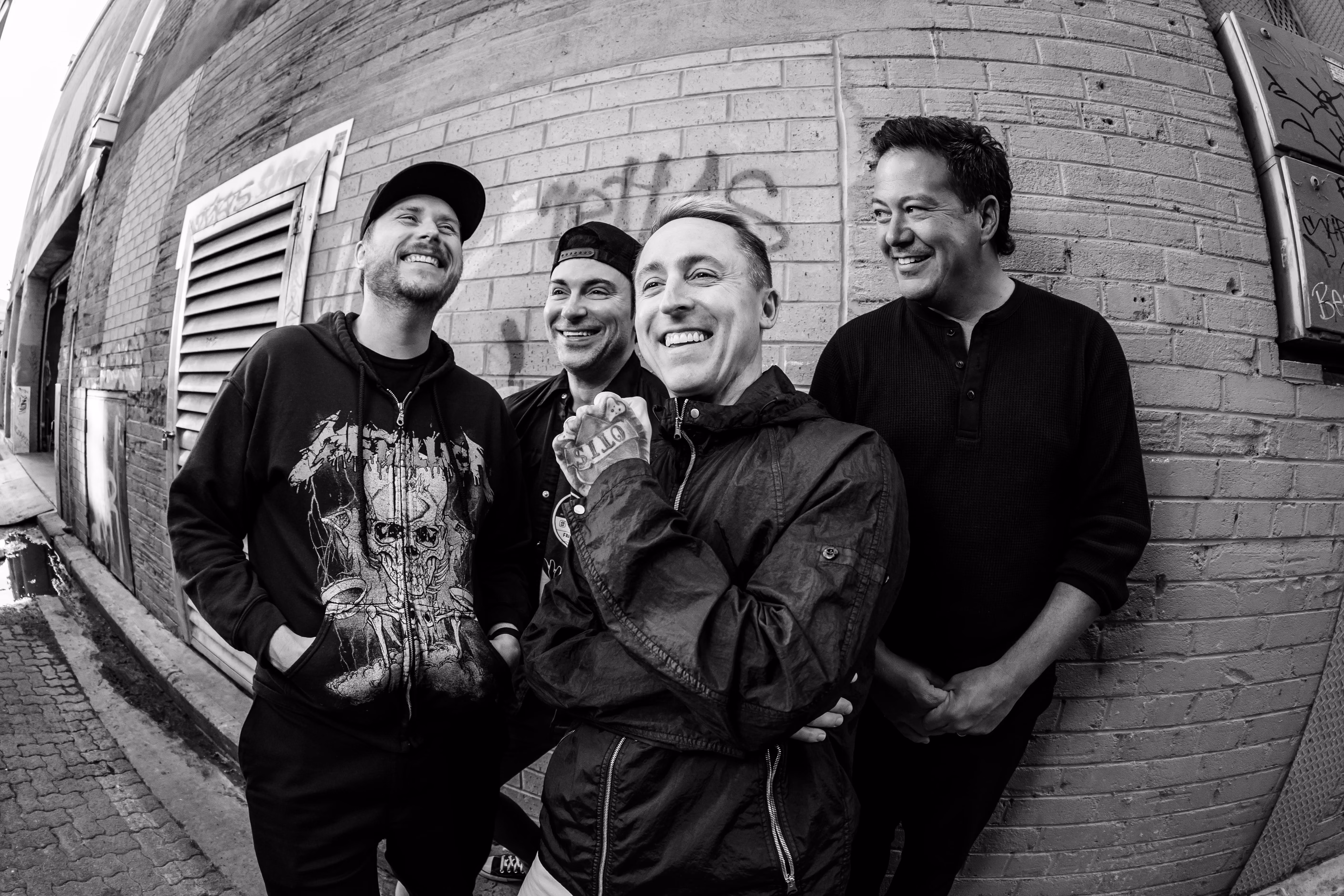 Ryan Key and Yellowcard band members pose in front of brick wall