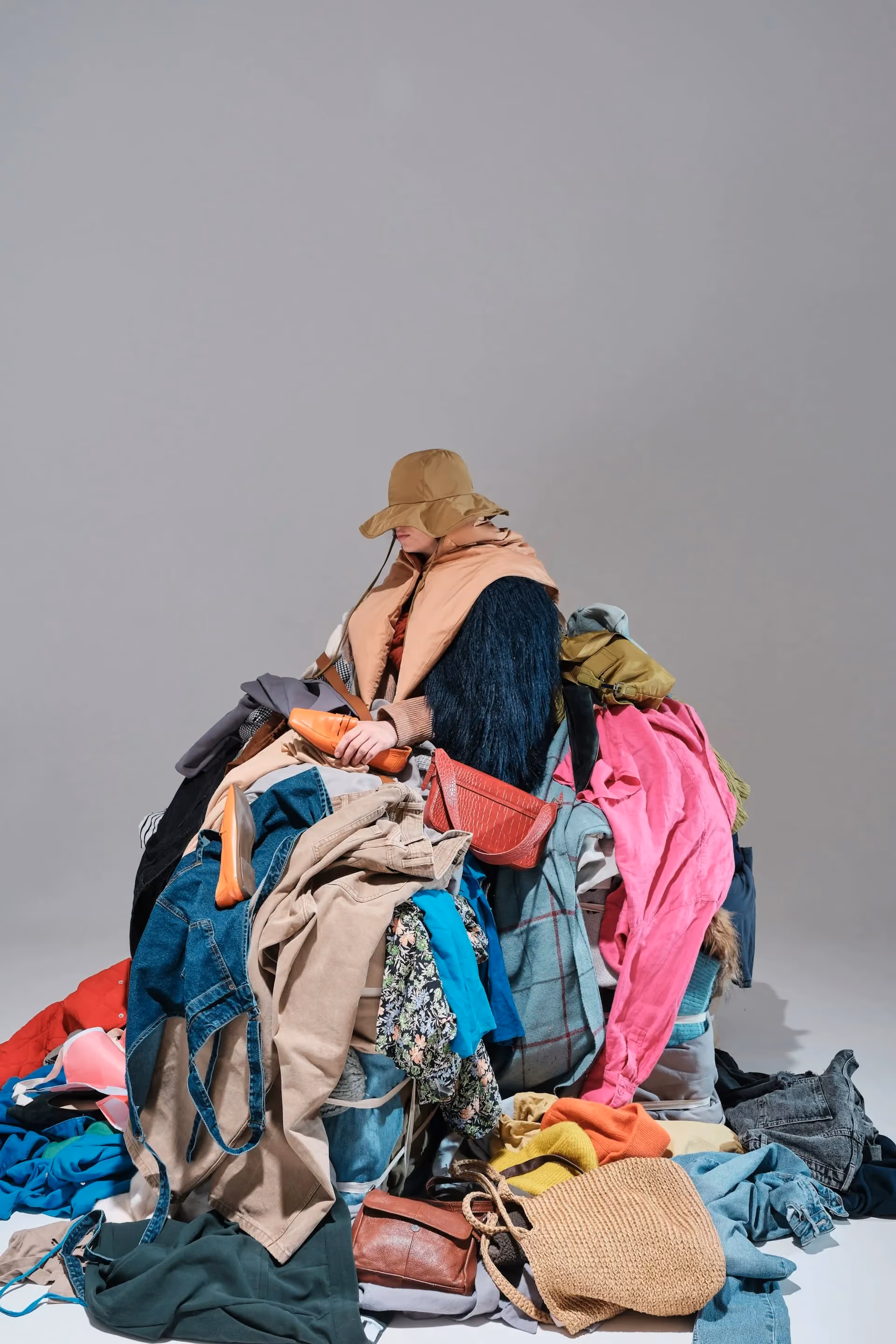 Conceptual photo of a pile of clothes overloading a model