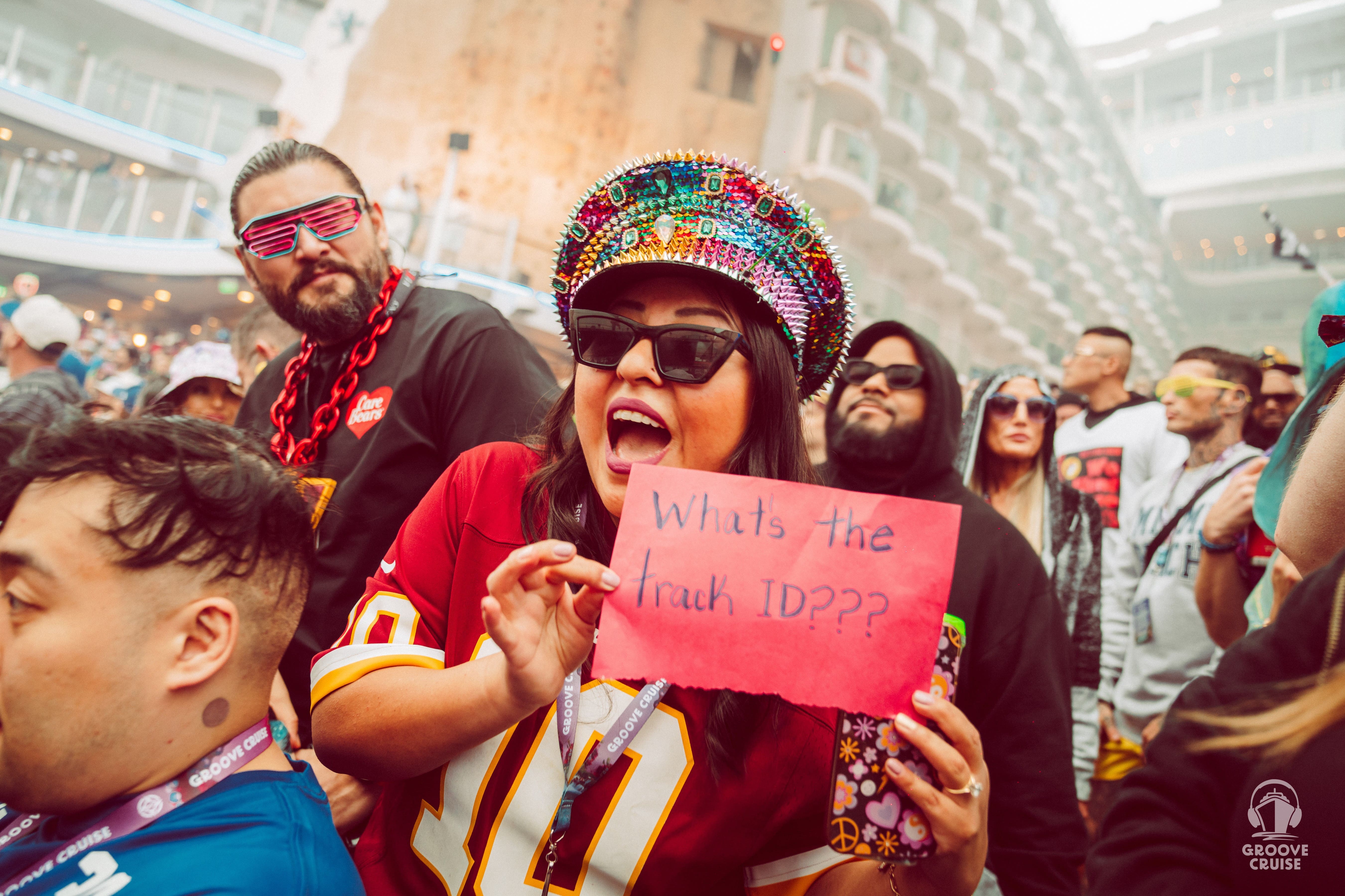Groove Cruise Captain holding up a sign that says “What’s The Track ID?”