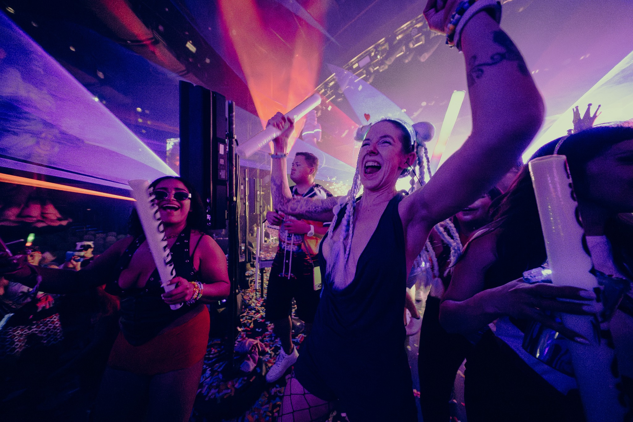 Miami rave cruise attendees cheering and dancing.