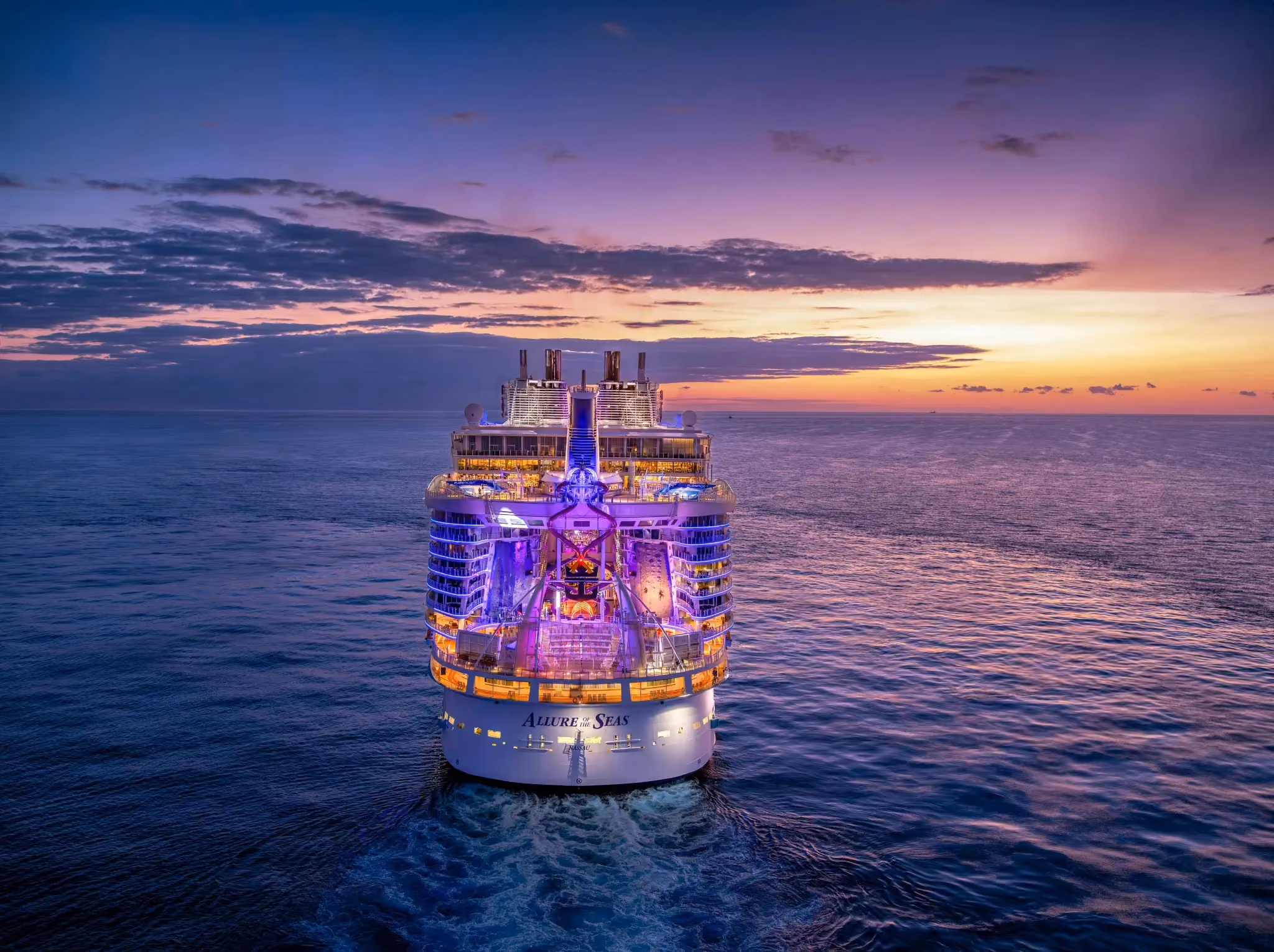 Rave cruise aboard Allure of the Seas sailing at sunset