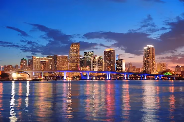 Nighttime Miami waterfront skyline with bridge