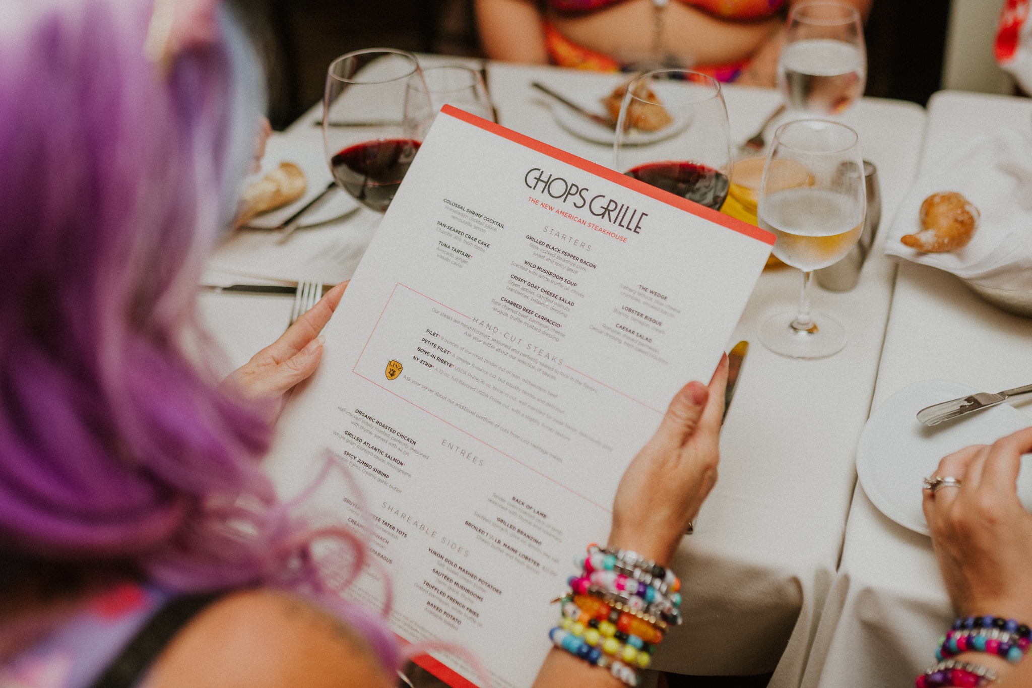 Rave cruise attendee viewing the Chops Grille menu aboard Allure of the Seas