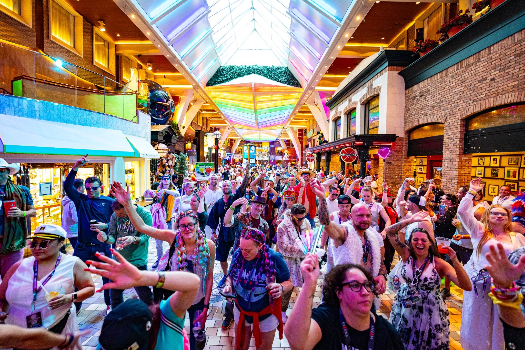 EDM cruise festival goers dancing in the Royal Promenade aboard Allure of the Seas