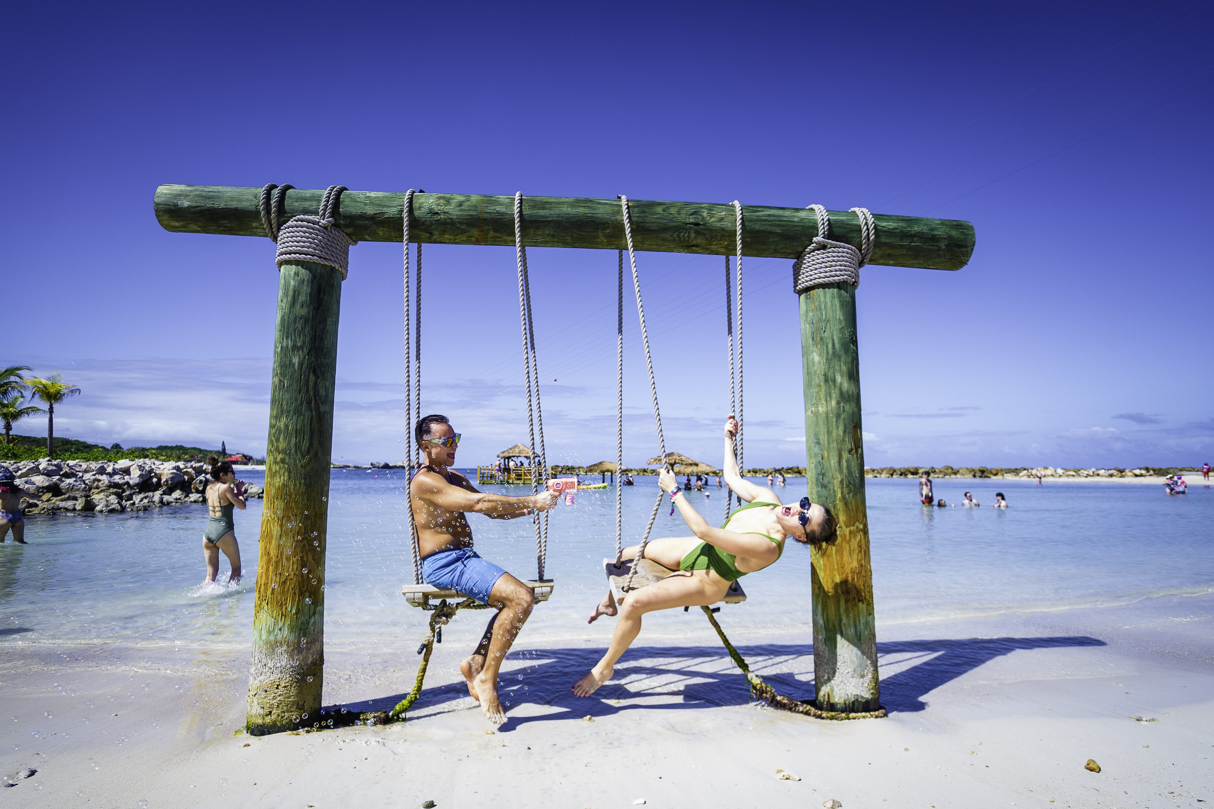 Couple relaxing on beach swings during a Groove Cruise destination day