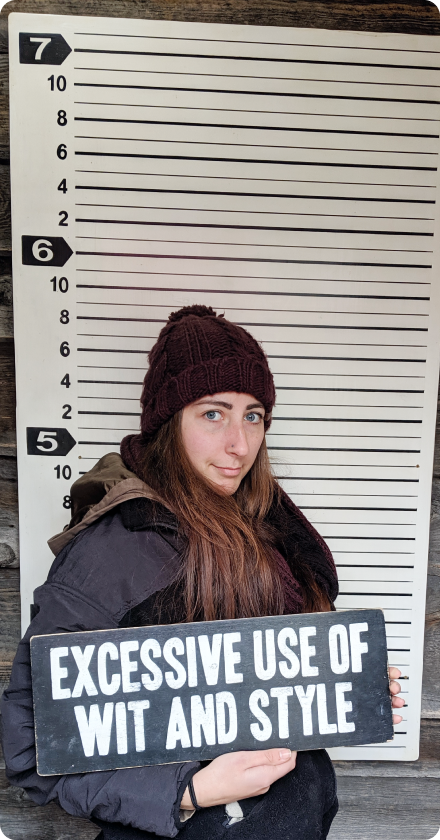 Photo of Mariah holding a sign that says "Excessive use of wit and style"