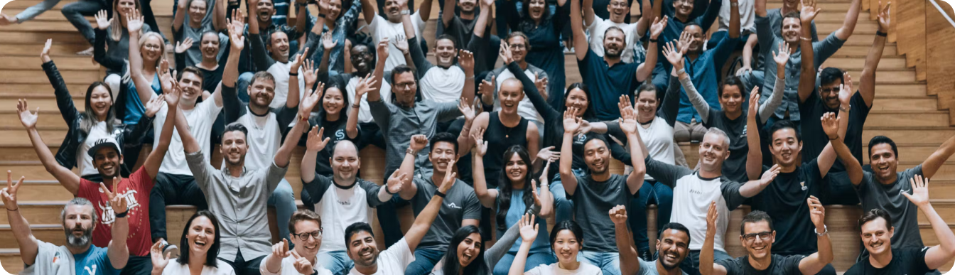large group of team members with hands in the air