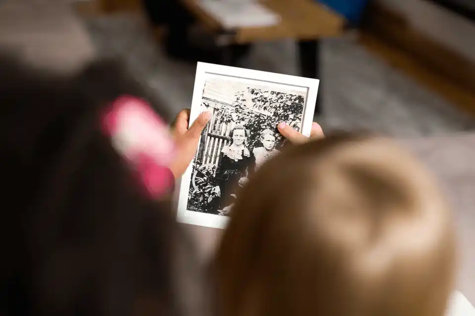 Child looking on old photography of her ancestors