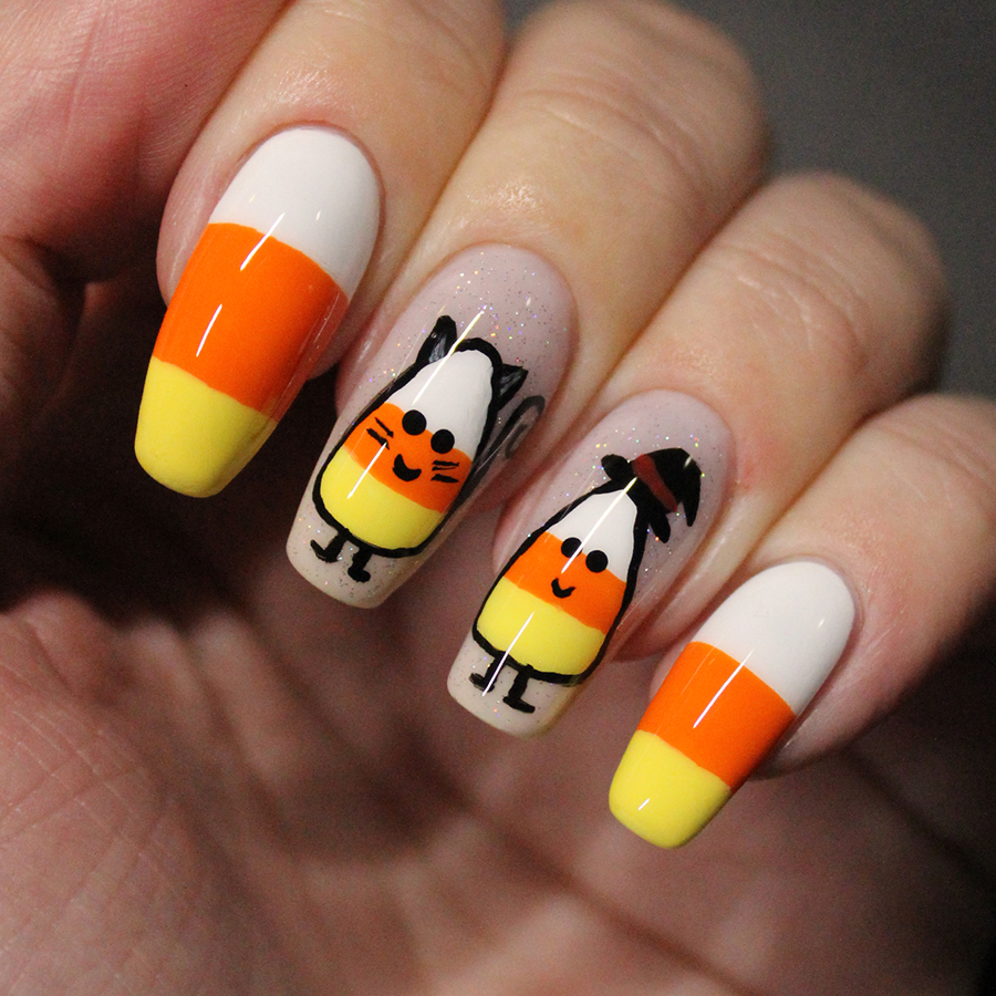 Nails painted with candy corn people wearing Halloween costumes