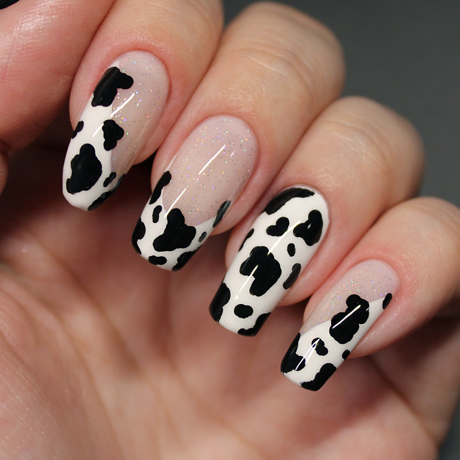 Nails painted with cow print nail art