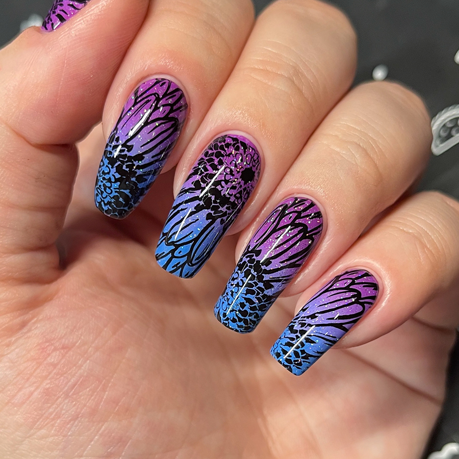 Nails with flower nail art over a purple and blue gradient