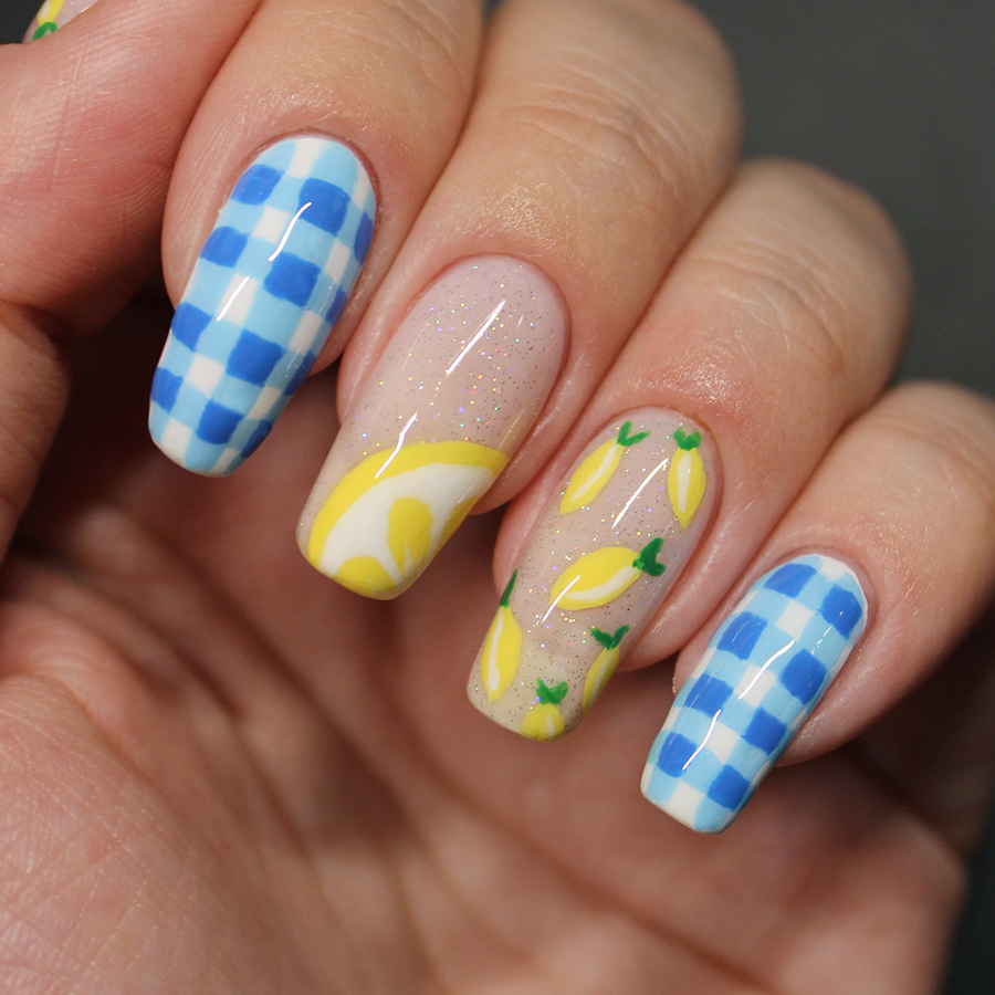 Nails painted with lemons and blue gingham patterned nail art