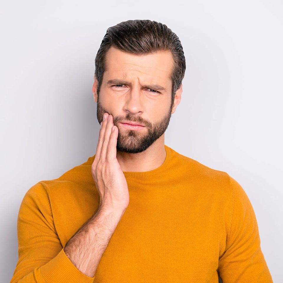 Adult experiencing a toothache at home