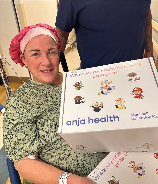 Carmela in her hospital gown and pink cap, holding her Anja Health collection kit