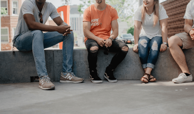4 people sitting outside talking