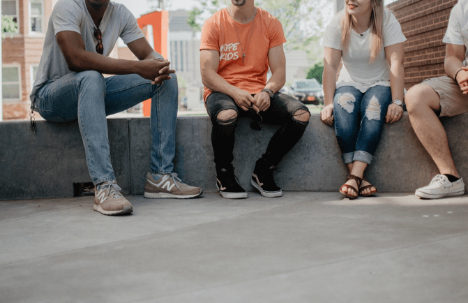 4 people sitting outside talking