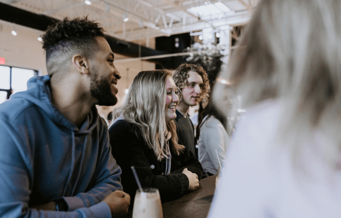 Young people sitting at a table talking