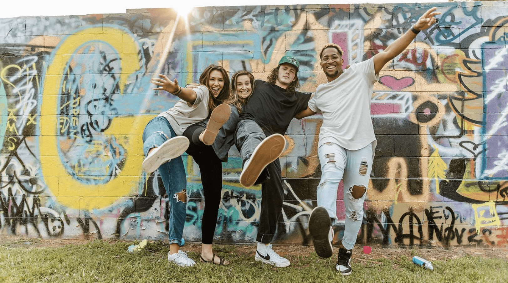 4 young adults smiling