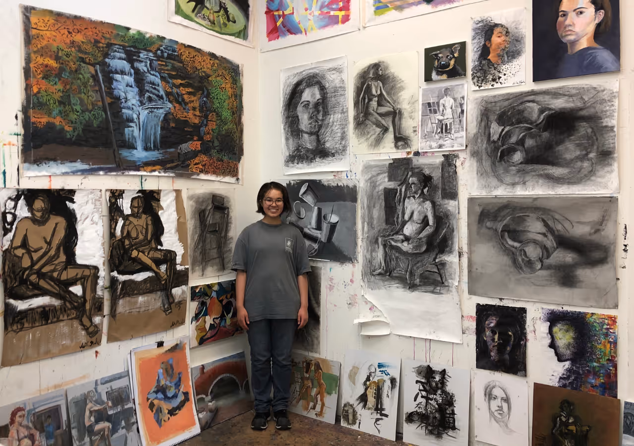 An artist student standing with her portfolio