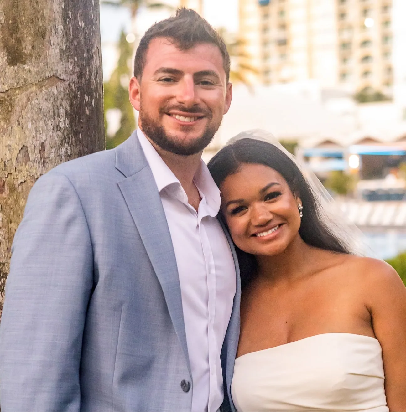 Smiling bride and groom at beach wedding.