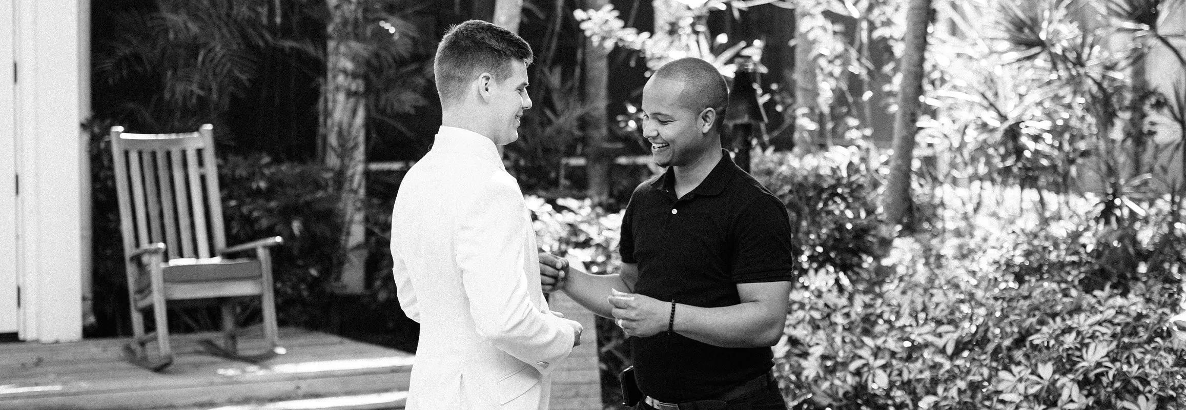 Wedding videographer setting up audio on groom