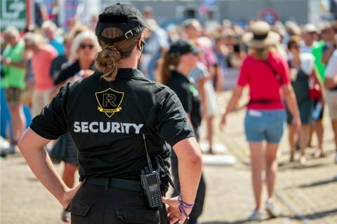 Two employees of Force Response Security – a woman and man –stand on a balcony.